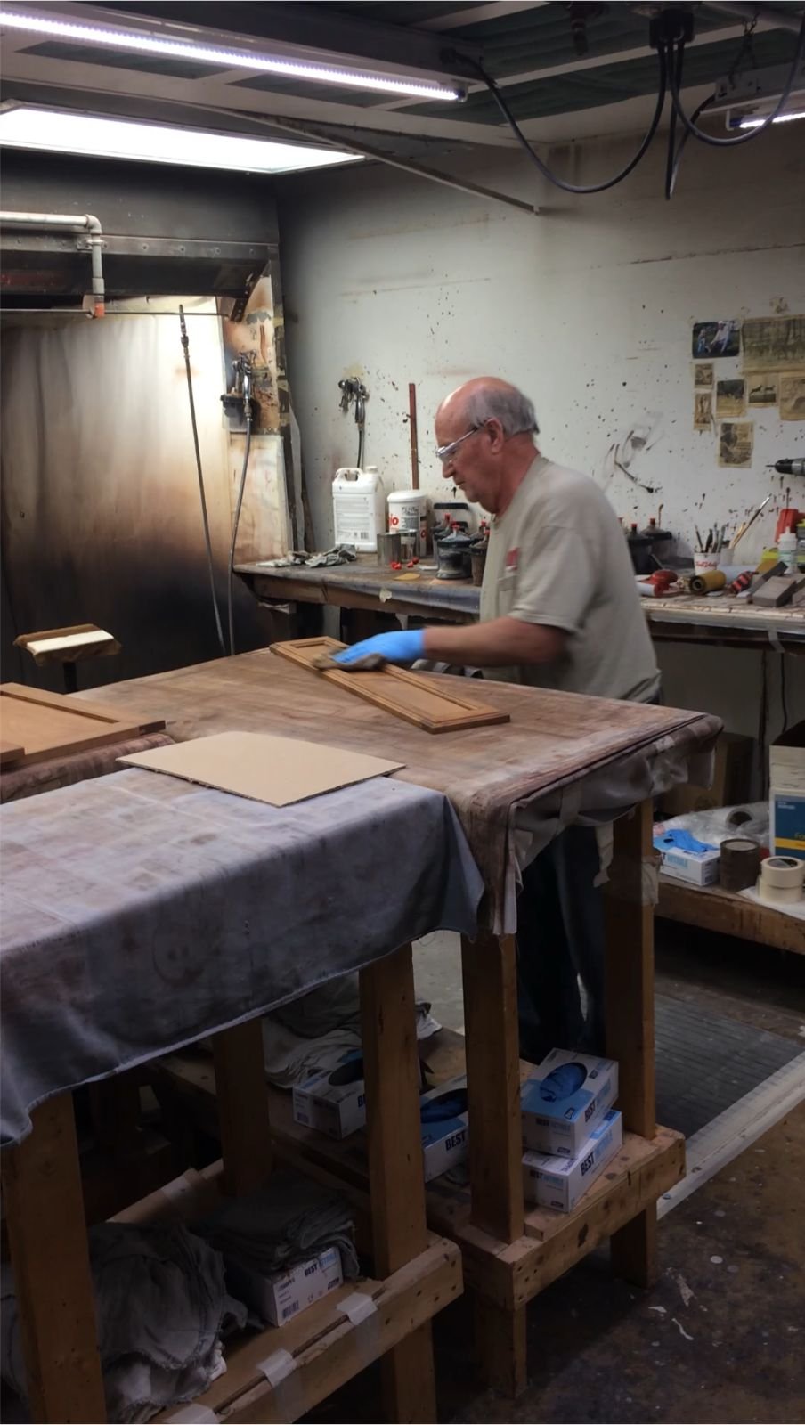 Cabinet refacing shop work, technician finishing cabinet doors before installation