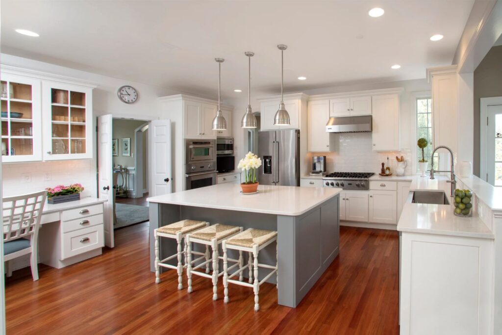 Cabinet refacing transitional white kitchen with gray island, pendant lights, and quartz countertops