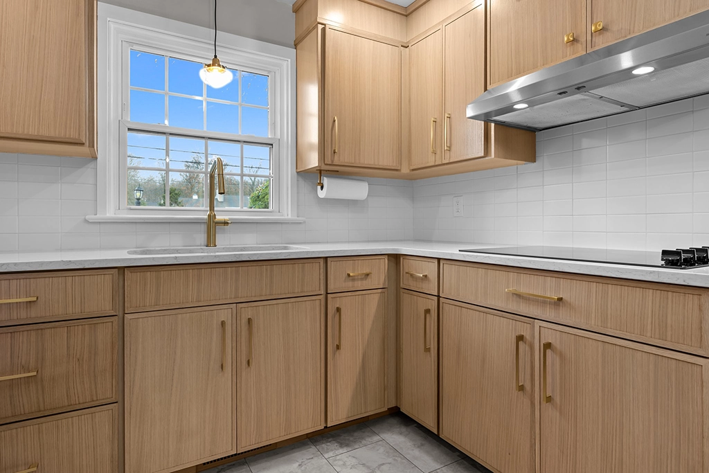 White oak cabinet refacing with quartz countertop, undermount sink, and brass hardware