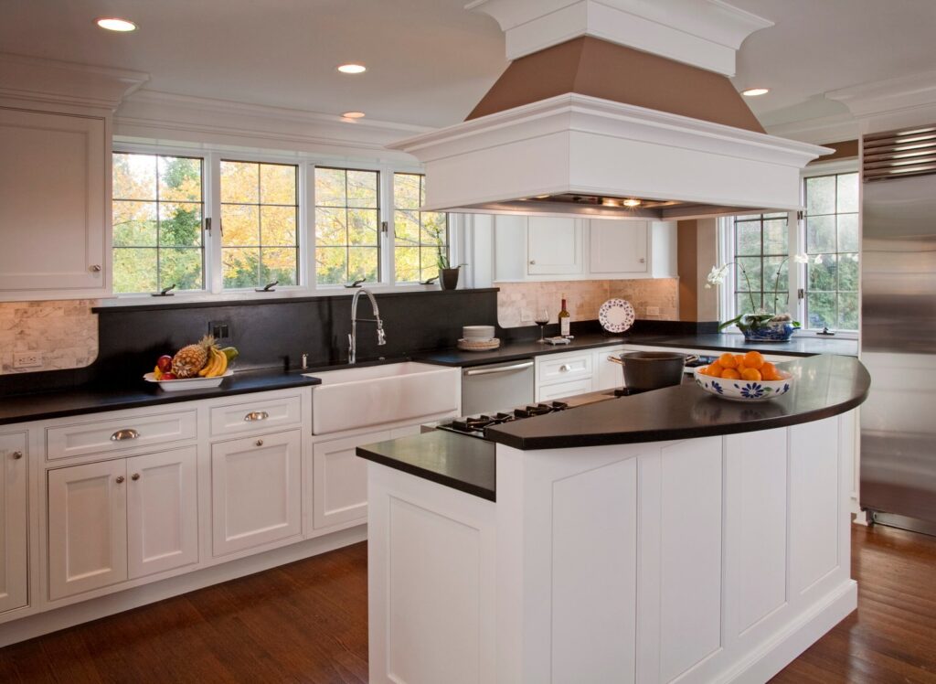 Custom white kitchen island with black countertop and built-in cooktop in Bryn Mawr, PA