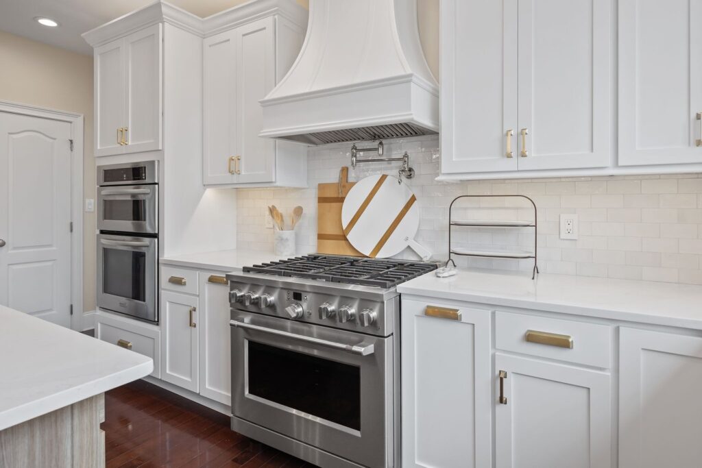 Custom white shaker transitional cabinet refacing with decorative hood and brass hardware in New Hope, PA
