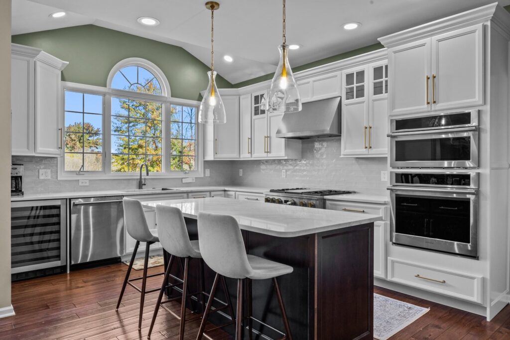 Higher-range cabinet refacing cost example in Furlong PA with white maple cabinets, dark island, quartz countertops, custom hood, and tile backsplash