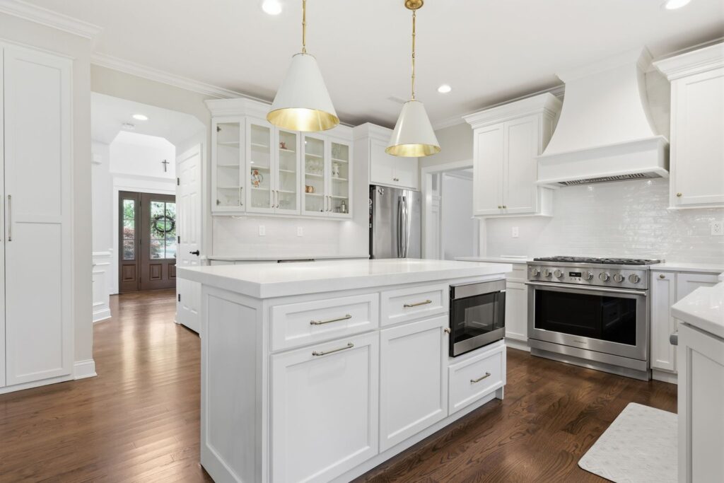 Premium custom cabinet refacing cost example in Pipersville PA with white cabinets, custom island, quartz countertops, custom hood, and pantry storage